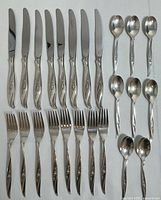 Full set laid out: 8 knives, 8 forks, 8 spoons