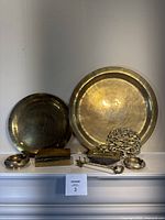 Overview showing two trays, box, inkwell, chain trivet, key, ashtrays