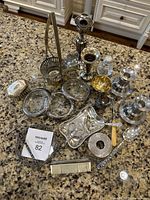 Full view of entire lot on countertop showing candlesticks, coasters, basket, trinket pieces, comb, spoon and other items