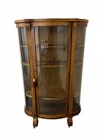 Full frontal view of oak cabinet showing curved glass door and base