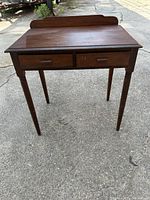 Front view of antique desk showing two drawers and back splash.