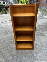 Front view of four-tier wooden bookshelf showing all shelves and open-top design.
