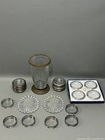 Overview of the entire set showing vase, coasters with metal rims, and boxed plaques