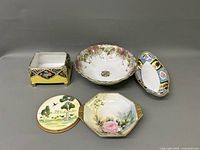 Photo of five porcelain items including a trivet, serving bowl, two dishes, and a decorative box.