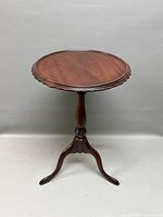 Full view of the round table showing scalloped edges and central column stand