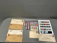 Photo of collection including six postal covers and various sheets and booklets of stamps.