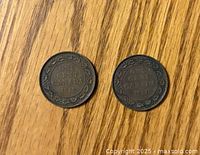 Photo of the reverse sides of the 1919 and 1920 Canadian large one cent pennies, showing denomination and years with decorative border.