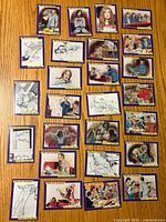 Front sides of 28 collectible trading cards with color illustrations depicting scenes related to crime, punishment, and Charles Manson.