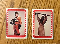 Front view of two Star Wars stickers from 1977 featuring Luke Skywalker and a Tusken Raider.