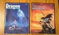 Front covers of Dragon magazines #174 and #173 side by side on wooden surface, showing fantasy artwork and titles.