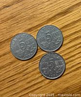 Three 1936 Canadian 5 cent coins showing reverse side with value and maple leaf design.