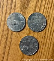 Reverse side showing detailed commemorative designs for 1973, 1983, and 1984 coins.