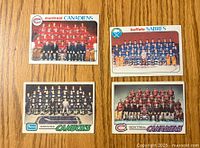 Front view of four 1970s hockey team cards featuring Montreal Canadiens (2), Buffalo Sabres, Vancouver Canucks.