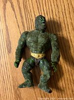 Front view of the vintage Moss Man action figure from He-Man series showing moss-like green textured body, yellow belt, brown loincloth, and detailed green hands and feet.