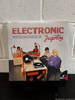 Front cover of the Electronic Jugoton Volume 1 2LP vinyl record featuring four people at synthesizer desks with retro style and grid background.