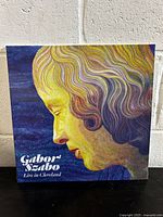Front cover of the vinyl record showing a colorful artistic portrait of Gabor Szabo with text 'Gabor Szabo Live in Cleveland'.
