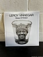 Front cover of the Leroy Vinnegar Glass Of Water vinyl record, showing a black and white photo of Leroy's face inside a glass of water.