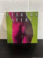 Front cover of sealed Niagara Afire vinyl record album showing vibrant abstract design in green and pink.