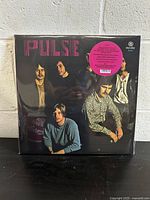 Front cover of the sealed 'Pulse' vinyl record showing the band members and title with a pink sticker indicating brand new condition.