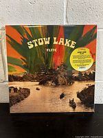Front cover of Stow Lake Flite vinyl record, showing lake and boat scene with psychedelic multicolor paint splashes, sealed in shrink wrap with a sticker.