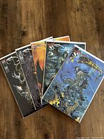 Five comic books from The Darkness series arranged fanned out on wooden floor, each with vibrant cover art and individually bagged.