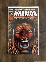 Close-up photo of The Ultimate Warrior #1 comic book cover showing detailed artwork and vibrant colors.