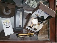 Photo showing His & Her designer wristwatches in box, two pens, Coach watch strap, and auction card.