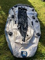 Full view of the deflated 11 foot inflatable boat on grass, showing overall condition and shape.