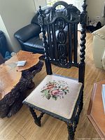 Full view of the antique Victorian side chair showing dark carved wood and needlepoint seat