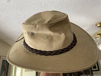 Full view of tan Jacaru leather hat showing wide brim and braided band