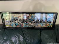 Full view of the Captain America wall hanging showing comic strip panels with overlay text.
