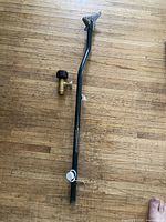 Green metal propane distribution tree pipe with multiple outlets on wooden floor.