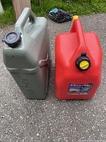 Front view of green water can and red gasoline can. The red gasoline can has a yellow vent cap and a black twist cap. The green water can has an enlarged black screw cap and handle.