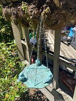 Front angle of a green hanging bird feeder with three sculpted birds and metal hanging chains attached