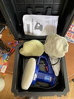 Simoniz car polisher in blue, with carrying case, two polishing pads, protective cover, and instruction manual