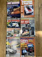 Top down photo showing six vintage 1970s car magazines with colorful covers related to hot rodding, muscle cars, and car customization.