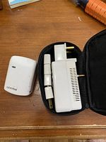 Top-down view of Leviton branded adapter components and carrying pouch on wooden surface