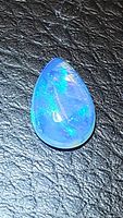 Front view of natural pear-shaped Ethiopian opal cabochon showing blue and green flashes.