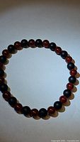 Photo of the natural gemstone beaded bracelet laid flat showing alternating red carnelian and black onyx beads.