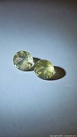 Two round lemon citrine gemstones side by side on white background showing diamond cut facets and yellow transparent color