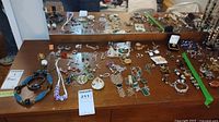 Overview of assorted jewelry spread across tabletop with mirror background