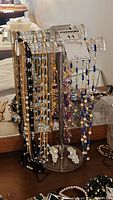 Front view of acrylic display stand loaded with necklaces