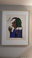 Full view of framed indigenous print showing the figure smoking, with bold colors and clean lines.
