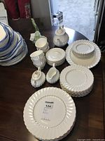 Overview of stacked dinnerware, cups, saucers, teapot, creamer and sugar bowl