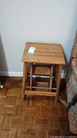 Front view of the folding oak step stool showing rectangular top and folding legs.
