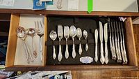 Full tray view showing sterling flatware and stainless knives in felt-lined drawer insert.