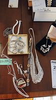 Overview of assorted silver necklaces, earrings, rings, bracelets, and pendants on table