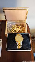 Wide view of Bulova watch in box with costume brooches