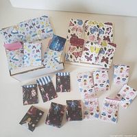Full assortment of 24 Alice in Wonderland themed mini paper pockets arranged flat and some holding gift cards