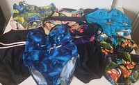 Photo showing seven bikinis of various designs and colors including black, blue, turquoise, and floral patterns